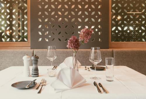 布鲁登茨巴拉兹阿尔卑斯山特拉布Spa高尔夫酒店的一张桌子,上面有白色的桌布和花瓶
