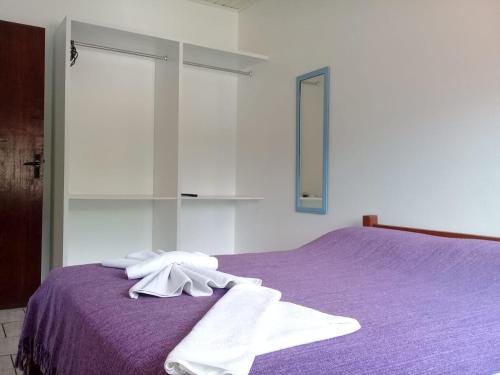 弗洛里亚诺波利斯Pousada Santo Sol的一间卧室配有一张紫色床和毛巾
