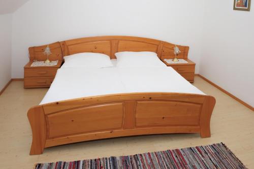 UnterretzbachWeinhof Gregor Raab的一张带白色床单的木床和2个床头柜