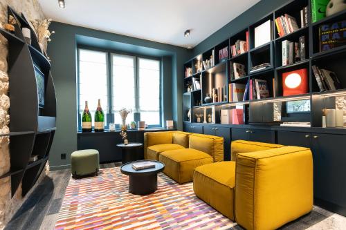 巴黎Hôtel Amoi Paris的客厅设有黄色椅子和书架