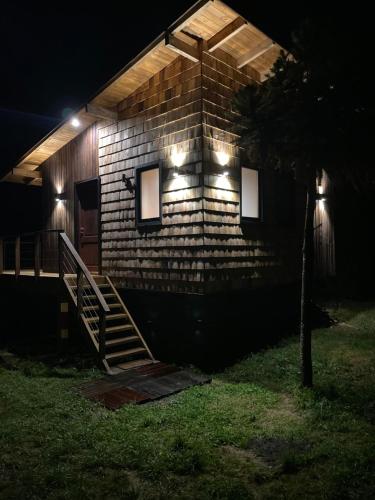 普孔Pucontours River Lodge的一间砖房,晚上有灯