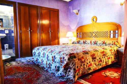卡萨布兰卡Hôtel Transatlantique的一间卧室配有一张带彩色床罩的床