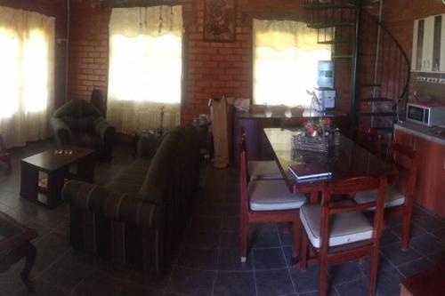 塔里哈Cabaña a orillas del Lago的客厅配有沙发和桌椅