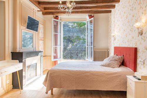 洛什La Little Maison的一间卧室设有一张床和一个大窗户