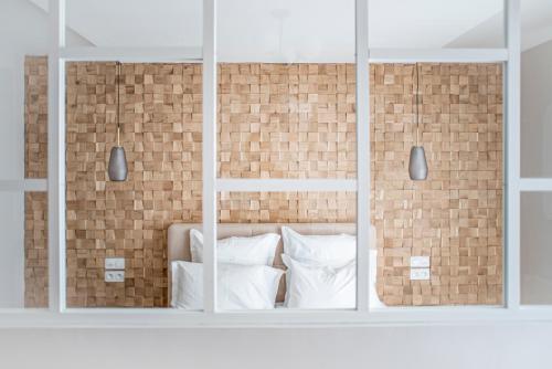 维勒班Suite Georgia的一张带白色枕头和砖墙的床
