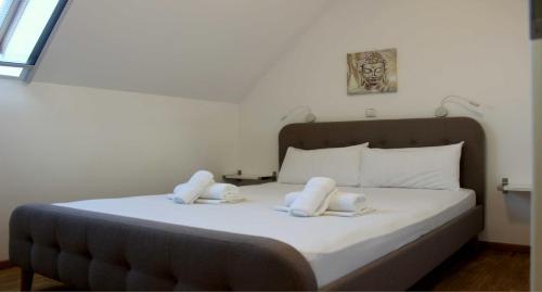 莱夫基米ANEMOMYLOS Lefkimmi LUXUS SUITES-BOUTIQUE HOTEL & POOL的一间卧室配有一张带两条白色毛巾的床