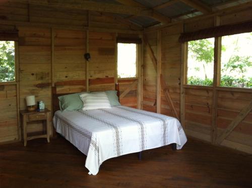 格拉纳达蒙巴卡山林小屋的小木屋内一间卧室,配有一张床