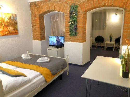 耶莱尼亚古拉Great Polonia Jelenia Góra City Center的一间卧室配有一张床,并在一间客房内配有电视。