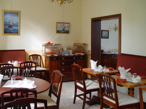 罗斯托克旧海港大厦酒店的一间带桌椅和柜台的用餐室