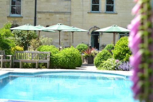 比纳克尔比撤菲尔德别墅酒店的一个带两把椅子和遮阳伞的游泳池