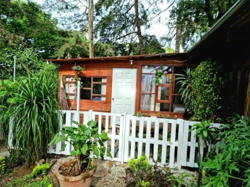 危地马拉CABAÑAS EN ZONA 16的一座带白色围栏的小木房子