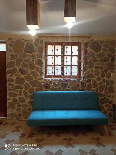 奥兰太坦波Doña Catta Casa Boutique的石头墙房里的蓝色沙发