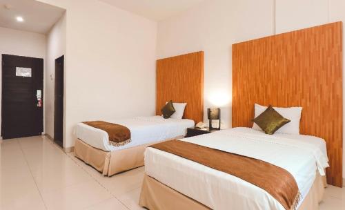 SunggalSaka Hotel Medan的一间酒店客房,内配两张床
