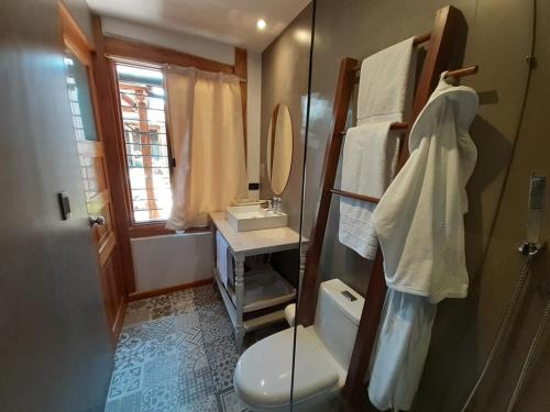 昆卡Hostal Suite Le Fabrique的一间带卫生间、水槽和镜子的浴室