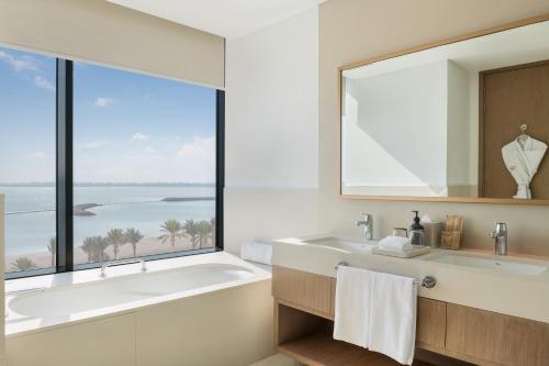 麦纳麦巴林马拉西海滩葳达度假村 的带浴缸的浴室和大窗户