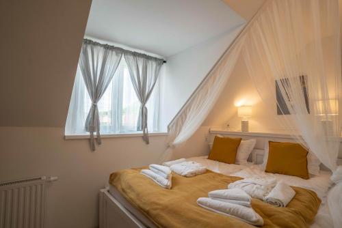 艾格扎洛克Tündérliget Panzió的一间卧室配有一张大床和毛巾