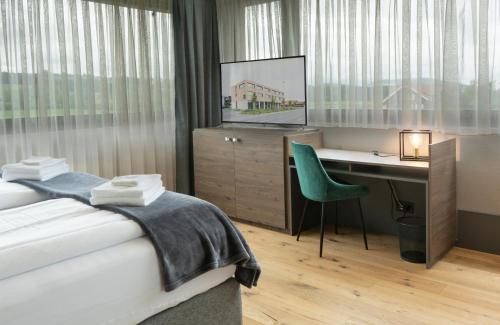 NeudorfWyna Motel的一间卧室配有一张床、一张书桌和一台电视