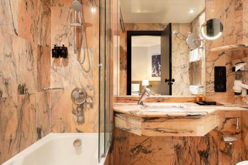 巴里尼古拉斯酒店的带浴缸、水槽和镜子的浴室
