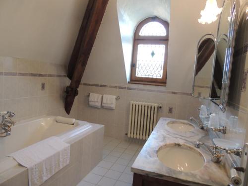 利梅伊维特拉酒店的一间带两个盥洗盆、浴缸和窗户的浴室