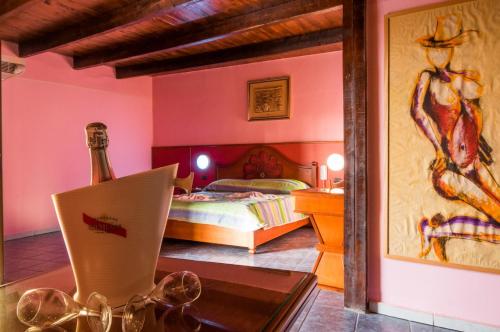 里克拉cupido park的一间卧室配有一张床和一张桌子及一瓶葡萄酒