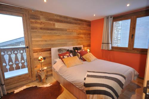 葱仁谷VALTHOSNOW的一间卧室设有一张床和木墙