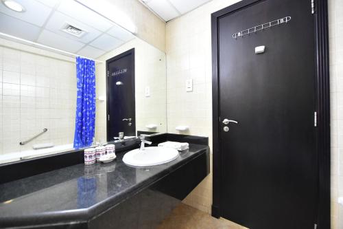 迪拜Budget-Friendly Studio Near Metro - Spacious & Calm - VRN的黑色浴室设有水槽和黑色门