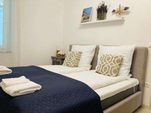 巴拉顿城堡ZAWIA APARTMAN的一张带蓝色毯子和枕头的床
