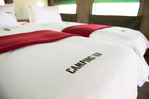 奥考奎约Etosha Safari Camping2Go的两张带被子的白色床,上面写着校友的字样