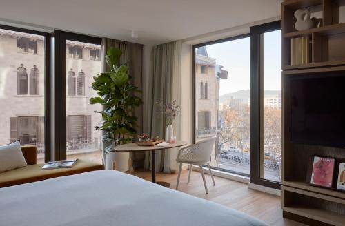 巴塞罗那ME Barcelona的酒店客房设有一张床和一个大窗户