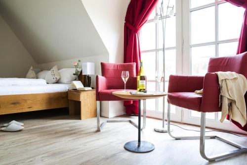 富伦多夫Holiday house, Fuhlendorf的一间卧室配有红色椅子、一张床和一张桌子