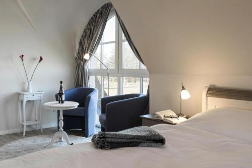 富伦多夫Holiday house, Fuhlendorf的一间卧室配有两把椅子、一张床和窗户