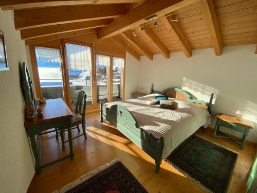 贝阿滕贝格Alpenparadies的卧室配有一张床、一张书桌和窗户。