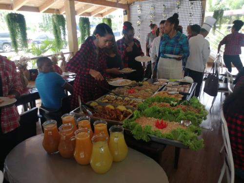 蓬塔卡纳My Home Hotel Punta Cana的一群人站在食物自助餐周围