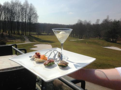 布林瑟姆Golf-Resort Brunssummerheide的一小盘食物和一杯葡萄酒