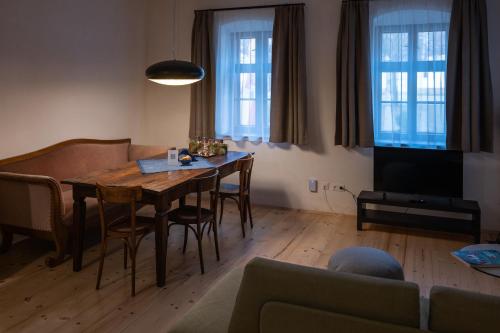 路茨曼贝格Tschardakenhof Appartements的客厅配有桌椅和电视。