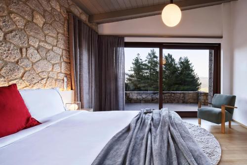 阿姆菲克利亚Alti Parnassos的一间卧室设有一张床和石墙