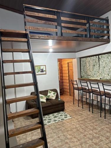 迦太基Cabaña Bambú的一张位于配有沙发和椅子的房间的阁楼床