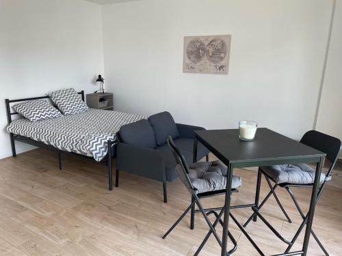 Noyal-sur-VilaineL'essentiel的卧室配有一张床和一张桌子及椅子