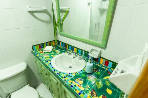 麦德林Hotel Casa Esencia的一间带水槽、镜子和卫生间的浴室