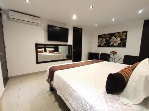 利马秘鲁蒙特瑞科酒店的卧室配有一张床,墙上配有电视。