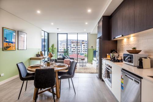 悉尼KULA Parramatta的厨房以及带桌椅的用餐室。