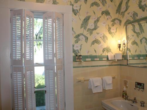罗克波特The Beech Tree B&B的一间带水槽的浴室和墙上鲜花窗户