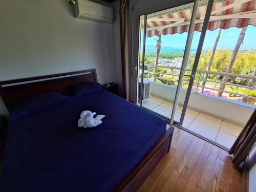 勒拉芒坦Le Lis Vacances et Affaire Cosy vue Mer的一间卧室配有一张蓝色的床,上面有毛巾