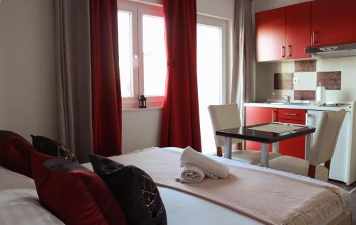 布雷拉艾米利亚公寓的一间设有桌子的房间和一间带红色橱柜的厨房