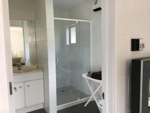 费尔利Mackenzie Motels的带淋浴和盥洗盆的白色浴室