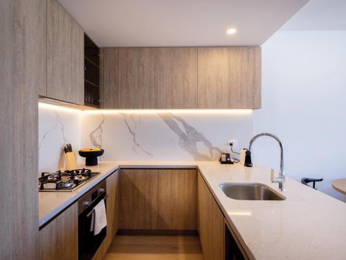 黄金海岸The Star Residences - Gold Coast的厨房配有水槽和炉灶 顶部烤箱
