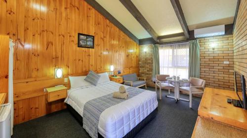 库纳巴拉布兰旅客汽车旅馆的卧室配有一张床铺,位于带木墙的房间内