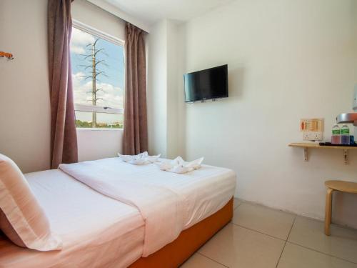 吉隆坡塔曼诺特1酒店的一间卧室配有一张带白色床单的床和一扇窗户。