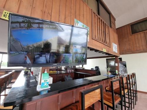 安吉利斯Heidi Sanctuary Resort by Cocotel的酒吧顶部的大屏幕平面电视