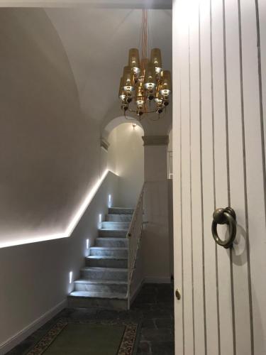 莫塔·圣塔纳斯塔西亚Motta Palace Apartments & Rooms的走廊上设有吊灯的楼梯